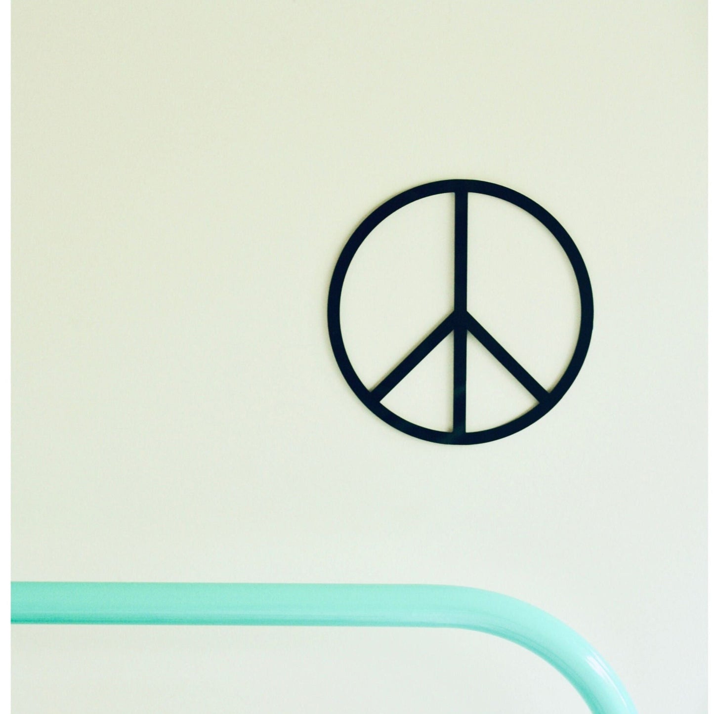 Peace symbol wall art on a light green background
